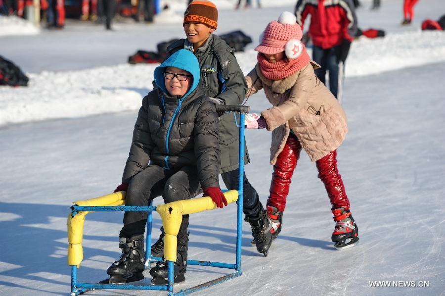 Three kids play at an ice rink inside the Nanhu Park in Changchun, capital of northeast China's Jilin Province, Jan. 17, 2015.