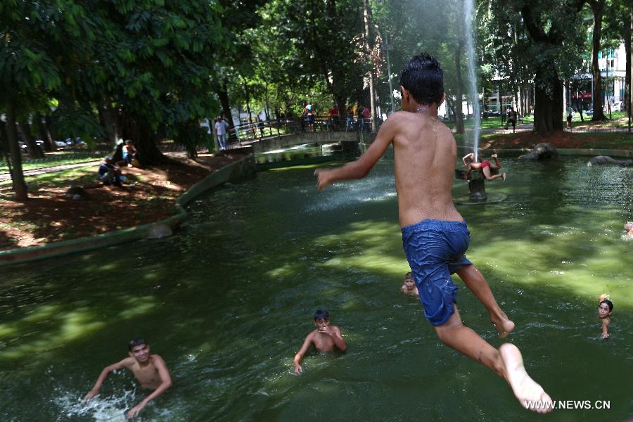 A boy jumps into a public fountain to cool off in downtown Sao Paulo, Brazil, on Jan. 19, 2015.