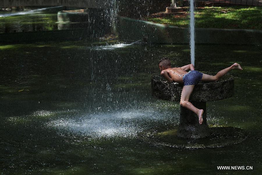 A boy plays in a public fountain to cool off in downtown Sao Paulo, Brazil, on Jan. 19, 2015.