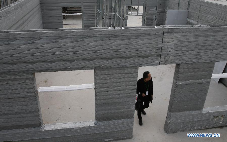 A visitor stands in a semi-finished apartment built by 3D printing technology in the Suzhou industrial park of east China's Jiangsu Province, Jan. 18, 2015.
