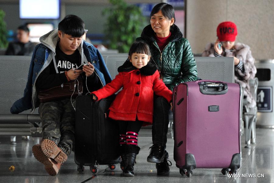 Four-year-old Wang Jiaqi (C) and her family members wait for their train home at the railway station of Yinchuan, capital of northwest China's Ningxia Hui Autonomous Region, Feb. 2, 2015.