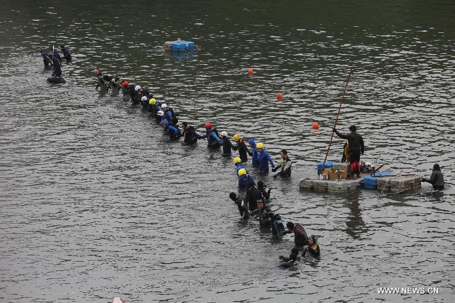 Rescuers search for missing passengers in the Keelung River in Taipei, southeast China's Taiwan, Feb. 6, 2015. Rescuers expanded the search area for the missing passengers Friday and two more bodies were recovered.