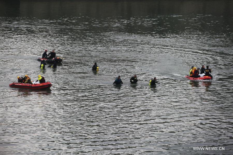 Rescuers transfer the bodies of two plane crash victims by rafts in Keelung River of Taipei, southeast China's Taiwan, Feb. 6, 2015.