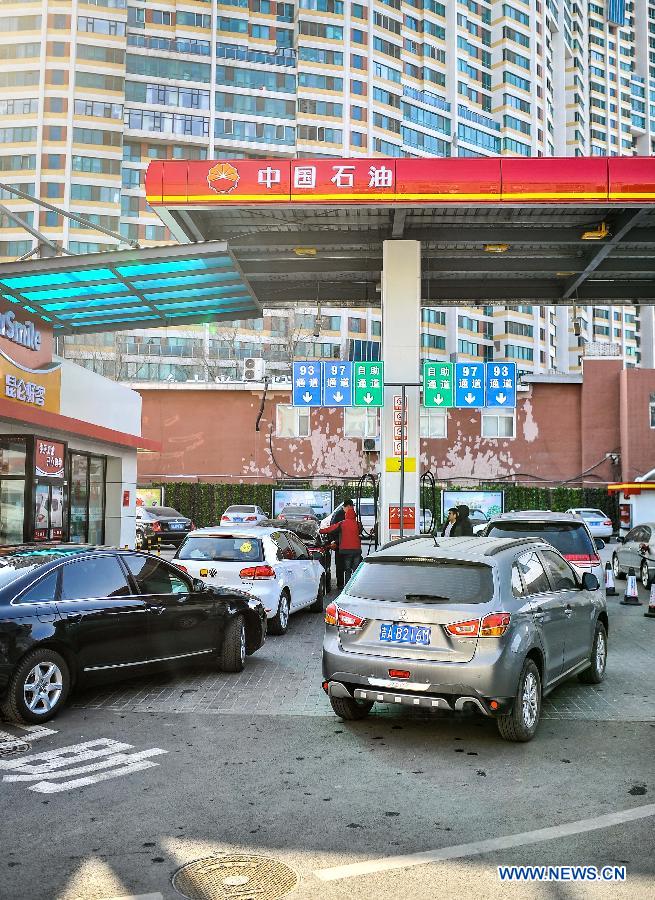 Vehicles wait to get fueled at a gas station in Changchun, capital of northeast China's Jilin Province, Feb. 9, 2015. 