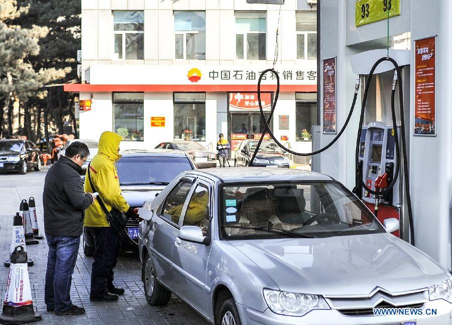 A worker fills up a car with fuel at a gas station in Changchun, capital of northeast China's Jilin Province, Feb. 9, 2015. 