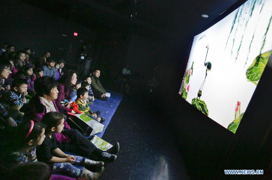 People watch a performance by the Beijing Shadow Play Art Troupe of China at the children's arts festival in Richmond, Canada, Feb. 9, 2015. Thousands of children participated in the 7th children's art festival at the Richmond Cultural Center.