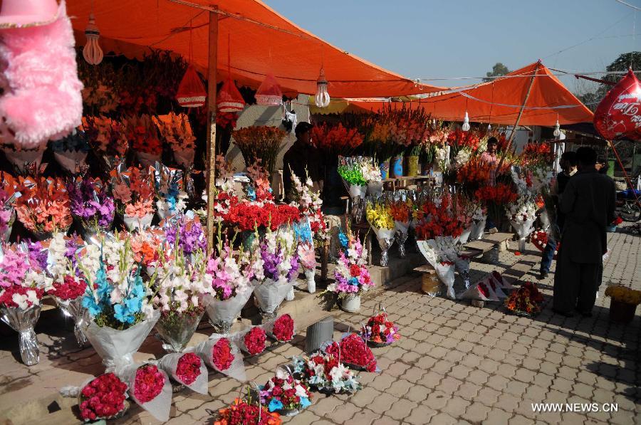 People buy flowers at a shop on the eve of Valentine's Day in Islamabad, capital of Pakistan on Feb. 13, 2015. (Xinhua/Ahmad Kamal) 