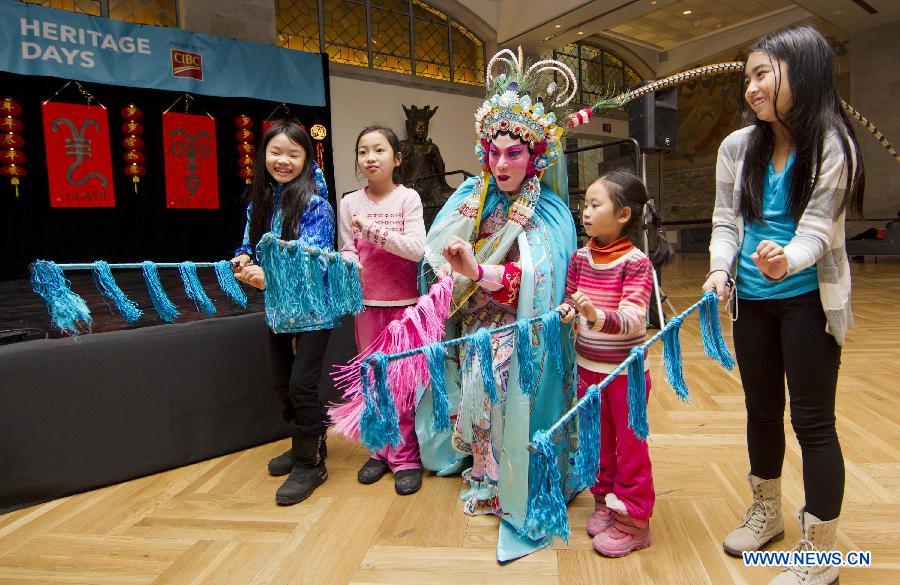 Kids learn Beijing Opera performance with a Beijing opera artist (C) during the 2015 Chinese New Year Extravaganza at the Royal Ontario Museum in Toronto, Canada, Feb. 14, 2015.