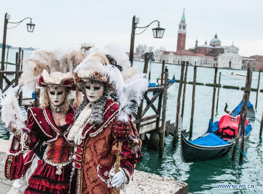 Costumed revellers pose during the Venice Carnival in Venice, Italy, on February 13, 2015. 