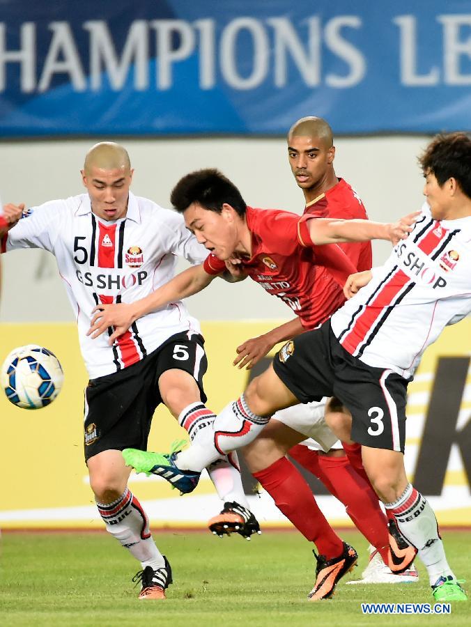 Li Xuepeng (2nd, L) of Guangzhou Evergrade breaks through during the AFC Champions League football match against Seoul FC in Guangzhou, China, on Feb. 25, 2015.