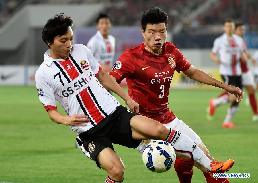 Mei Fang (R) of Guangzhou Evergrade vies for the ball with Kim Chi Woo of Seoul FC during the AFC Champions League football match in Guangzhou, China, on Feb. 25, 2015.