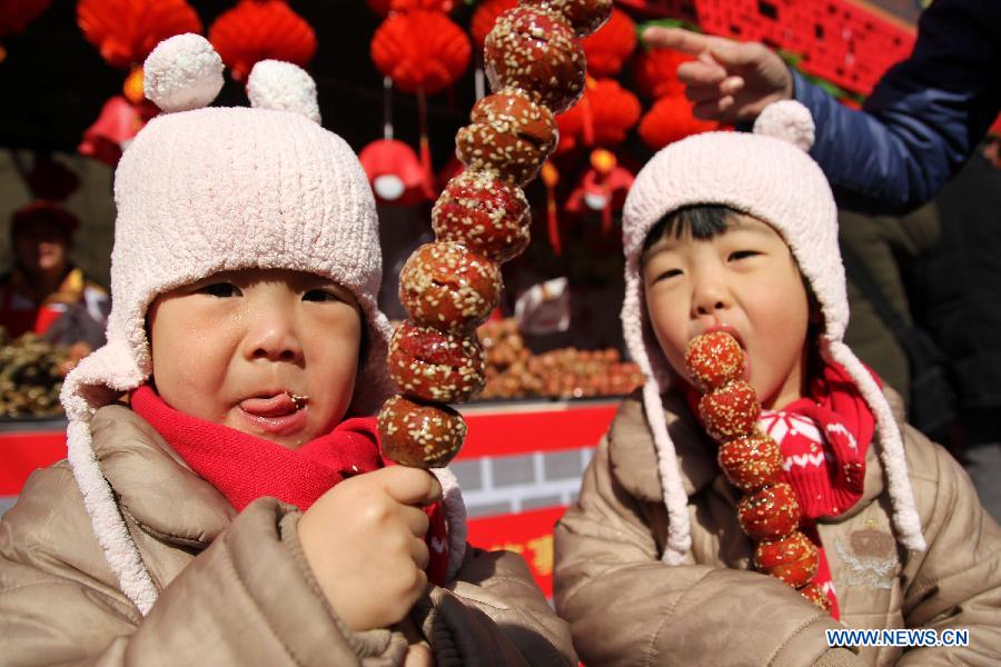 Children eat sugar balls at a temple fair before the coming Lantern Festival in Qingdao, east China's Shandong Province, March 4, 2015. The Lantern Festival falls on March 5 this year. (Xinhua/Huang Jiexian) 
