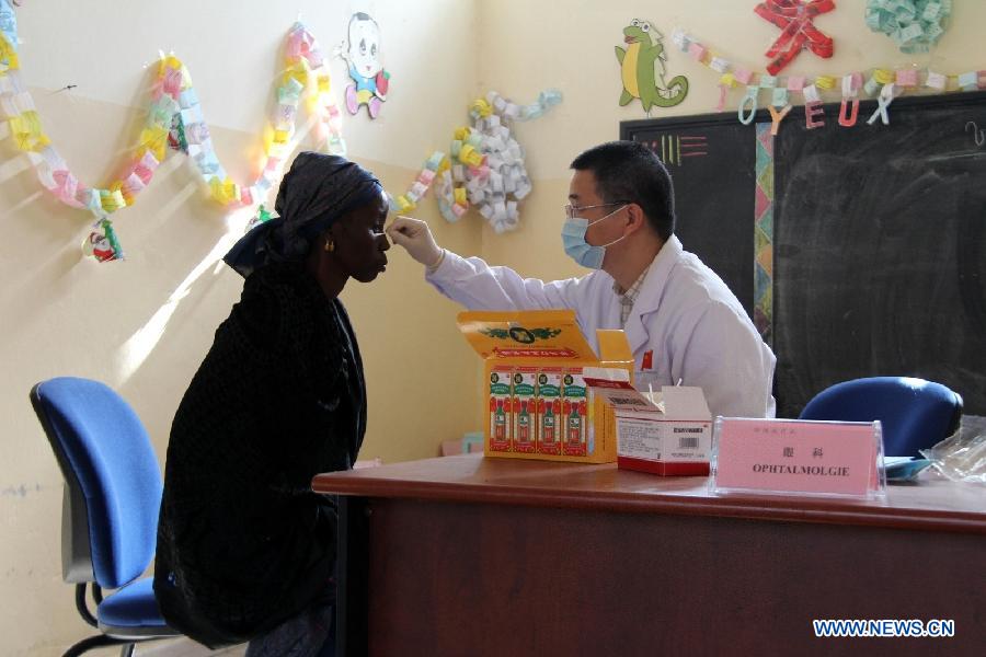 A doctor of Chinese medical team to Senegal examines the eyes of a local female patient in Darkar, capital of Senegal, Dec, 20, 2014. Since the outbreak of Ebola Virus Disease, China provided its aid in the first time and so far has sent successively several medical teams and four batches of emergency aid worth a total of 700 million yuan (around 112.2 million U.S. dollars) to the epidemic-hit countries, becoming one of the biggest donors to the infected areas and playing an important role in coping with the epidemic. (Xinhua/Wang Meng) 
