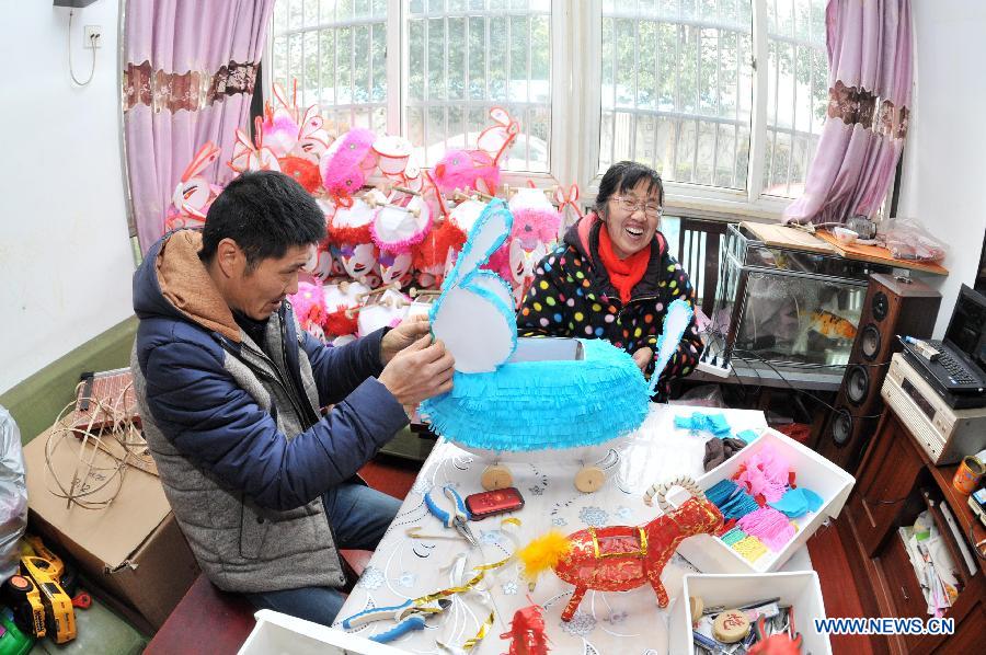 Gan Baodi (R) and her son Xie Yaodong make paper rabbits to celebrate the coming Lantern Festival in Changzhou, east China's Jiangsu Province, March 4, 2015. The Lantern Festival falls on March 5 this year. (Xinhua/Hu Ping) 