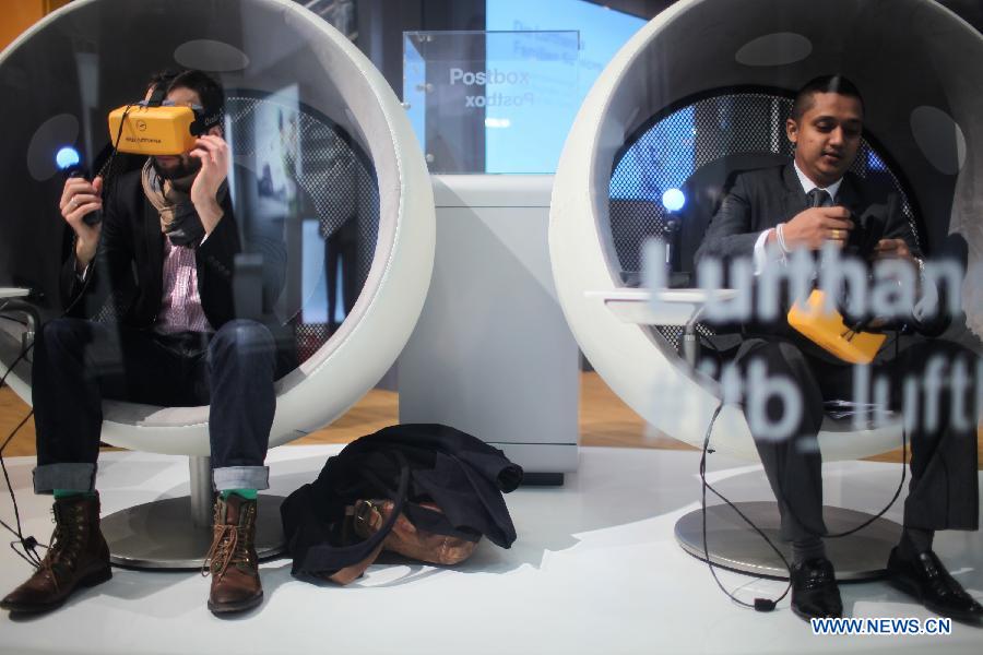 Visitors view virtual realities at the stand of the Lufthansa Airline during the Berlin International Tourism Fair (ITB), in Berlin, Germany, on March 4, 2015.