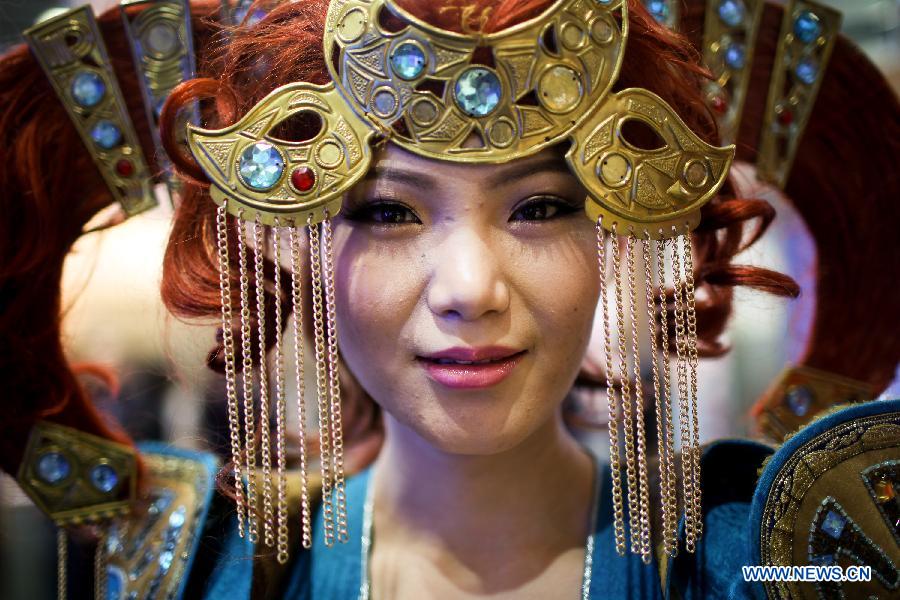 A Mongolian young woman displays traditional costumes at the stand of Mongolia, this year's partner country, during the Berlin International Tourism Fair (ITB), in Berlin, Germany, on March 4, 2015.