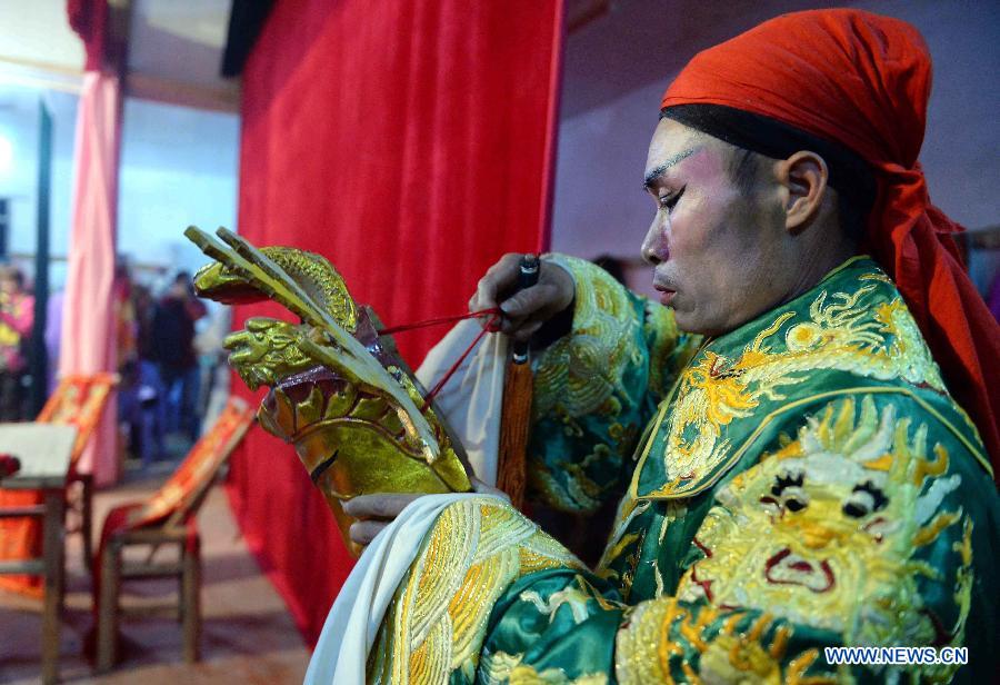 Wei Ruyi, a member of the local Meng Opera troupe, prepares for a performance in Shexi Village in Guangchang County, east China's Jiangxi Province, March 2, 2015. The Meng Opera is a local folk opera dated from early Ming Dynasty (1368-1644), and the current Meng Opera troupe was established by villagers in 1980. (Xinhua/Chen Zixia) 