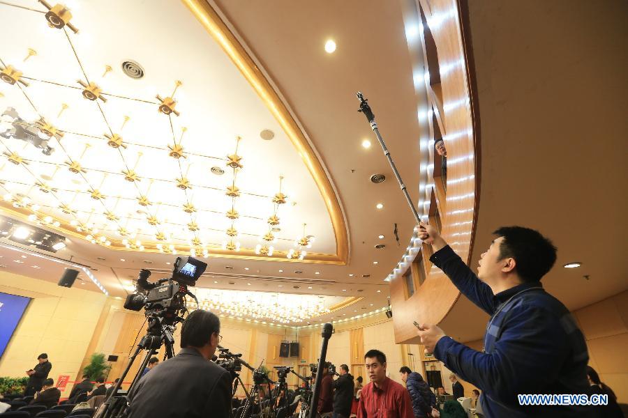 A journalist mounts a GoPro on top of his monopod to take photos during a press conference given by Chinese Minister of Commerce Gao Hucheng for the third session of China's 12th National People's Congress (NPC) on commercial development and opening up in Beijing, capital of China, March 7, 2015. (Xinhua/Xing Guangli) 