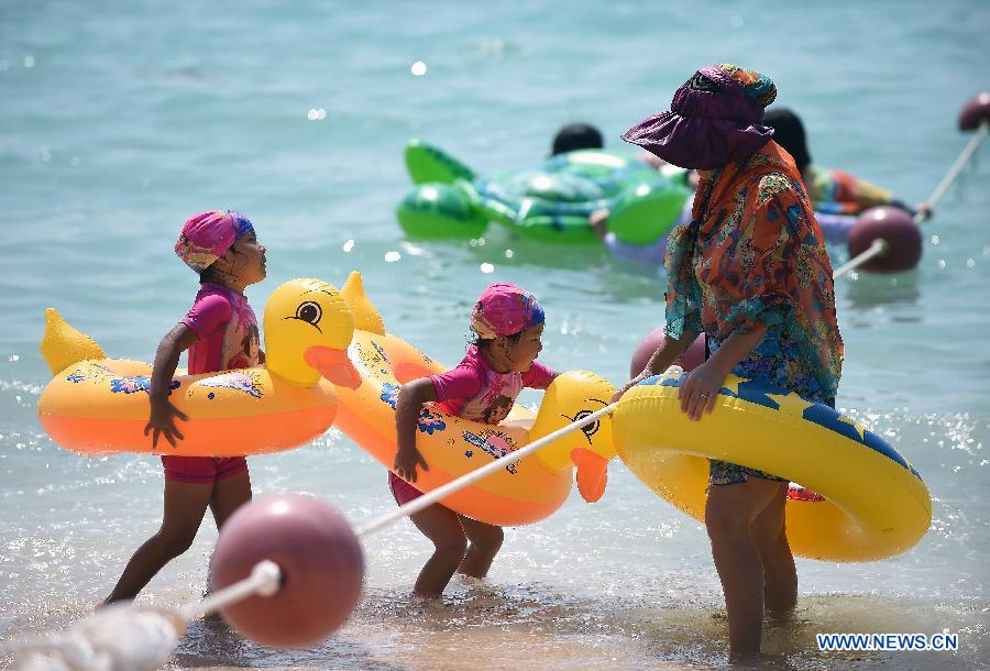 Tourists play on a beach in Sanya, a resort city in south China's Hainan Province, March 8, 2015.