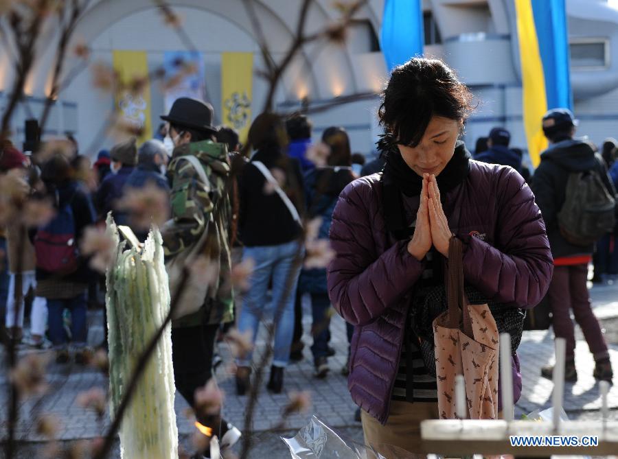 A woman offers prayers during a memorial service marking the 4th anniversary of the 2011 earthquake and tsunami that pummeled the eastern sea board and left more than 18,000 people dead or missing, in Tokyo, Japan, on March 11, 2015.