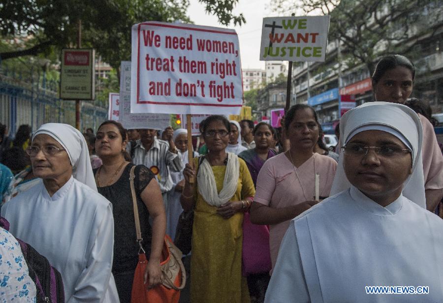 People participate in a candle light vigil to condemn the recent gangrape of a nun in Kolkata, capital of eastern Indian state West Bengal, March 16, 2015. 