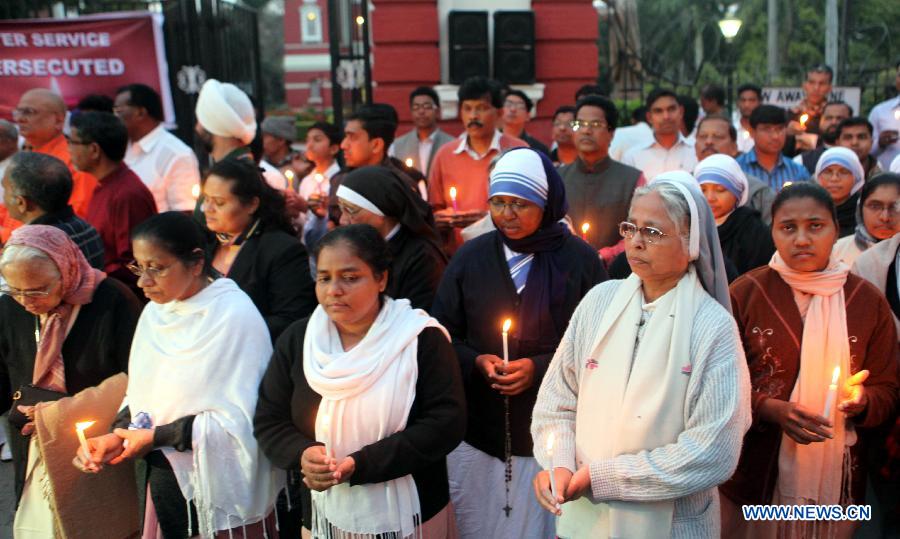 People pray outside the Sacred Heart cathedral during a candle light vigil to condemn the recent gangrape of a nun, in New Delhi, India, March 16, 2015. 