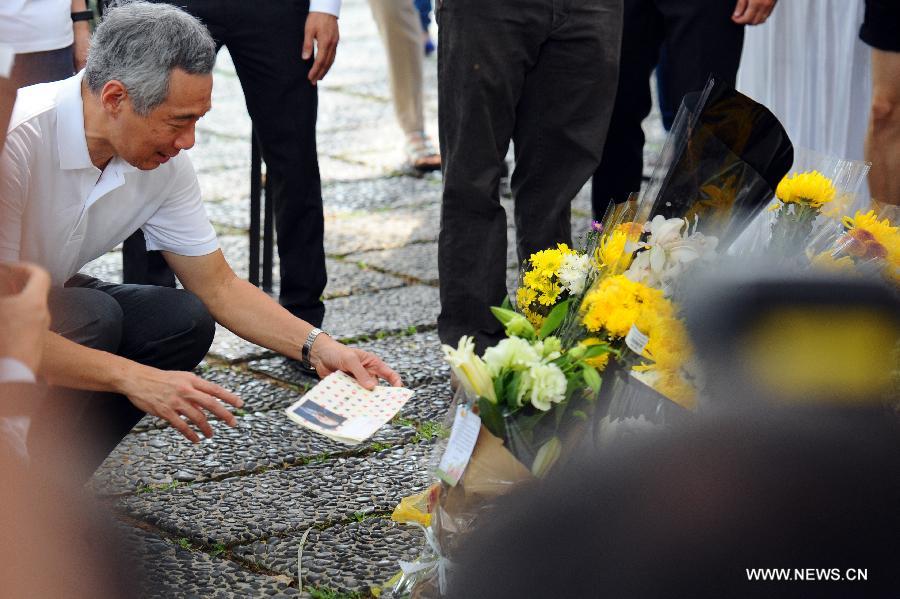 Singapore's Prime Minister Lee Hsien Loong views a condolence card at the Istana tribute site for Singapore's former prime minister Lee Kuan Yew in Singapore, March 24, 2015. Singapore's Prime Minister Lee Hsien Loong spoke to visitors at the Istana Gate on Tuesday when he stopped to read some of the messages left for Singapore's founding prime minister Lee Kuan Yew. (Xinhua/Then Chih Wey)