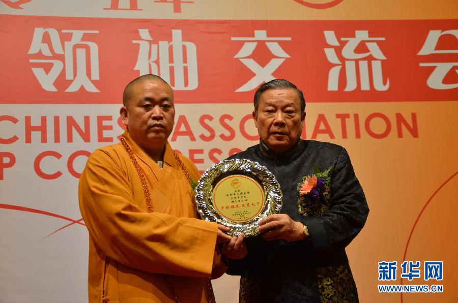 Cheng Wanqi (right), President of United World Chinese Association presents Outstanding Contribution Award to Shi Yongxin, current abbot of the Shaolin Temple, March 23, 2015. 'United World Chinese Association Leadership Conference 2015 ' was held in Kuala Lumpur, Malaysia, to promote exchange, win-win cooperation and innovation. (Xinhua/Wang Dawei)