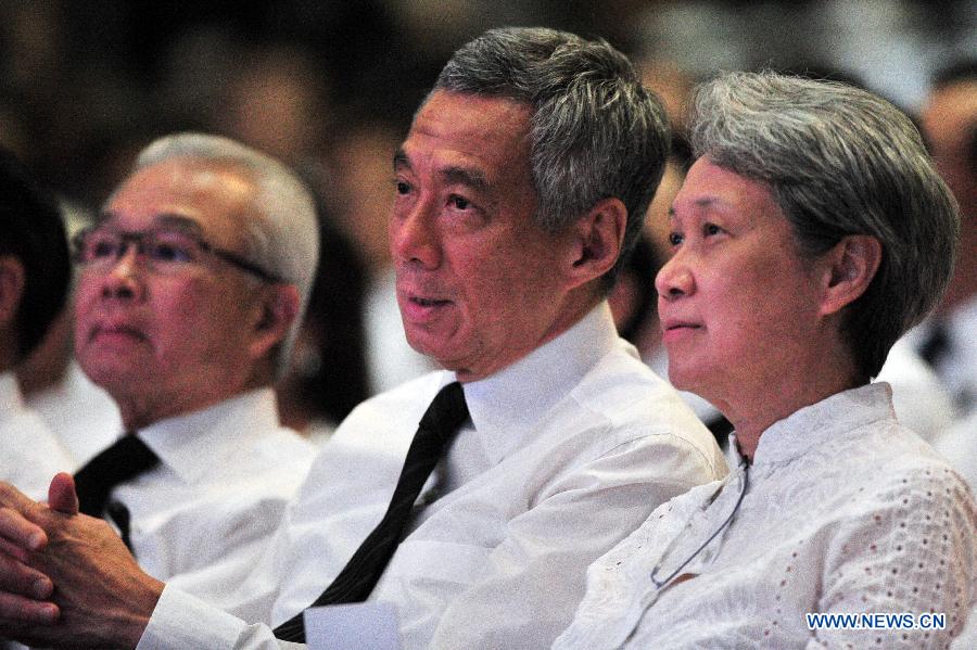 Singapore's Prime Minister Lee Hsien Loong (C) and his wife Ho Ching (R) attend a memorial meeting of Singapore's founding father Lee Kuan Yew at Singapore's Kallang Theatre, March 27, 2015. 