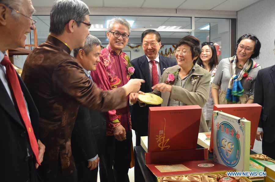 Tan Keng Kang (2nd left), chief operations executive of Malaysian Hai-O Group introduces Pu'er tea to Malaysia’s Vice Minister of Women, Family and Community Development Datin Paduka Chew Mei Fun (2nd right) at the opening ceremony of the Tea Town run by Malaysian Hai-O Group in Kuala Lumpur, March 30, 2015.