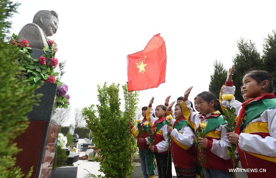 Pupils salute to the statue of Zhang Xiuyun, a martyr who sacrificed her own life to save a boy in 2005, in Hefei, capital of east China's Anhui Province, April 3, 2015. People started mourning for departed relatives and martyrs as the Qingming Festival is coming. (Xinhua/Xie Chen)