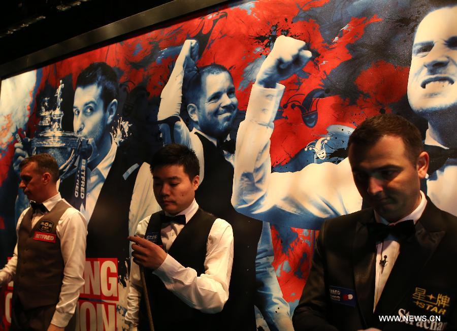 Ding Junhui (C) of China and Mark Davis of England are seen after a break during the first half of the first round match at the 2015 World Snooker Championship in Sheffield, Britain, April 20, 2015. Mark Davis led 4-3 in the first half. (Xinhua/Han Yan) 