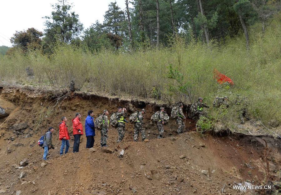 An armed traffic police team was using enginering machinery to repair the highway linking Gyirong Town and Gyirong land port which was blocked by multiple landslides, while 60 members of the team chose to walk to rescue trapped locals affected by Saturday's Nepal earthquake. (Xinhua/Liu Dongjun)