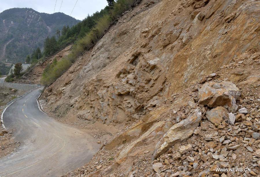 An armed traffic police team was using enginering machinery to repair the highway linking Gyirong Town and Gyirong land port which was blocked by multiple landslides, while 60 members of the team chose to walk to rescue trapped locals affected by Saturday's Nepal earthquake. (Xinhua/Liu Dongjun)