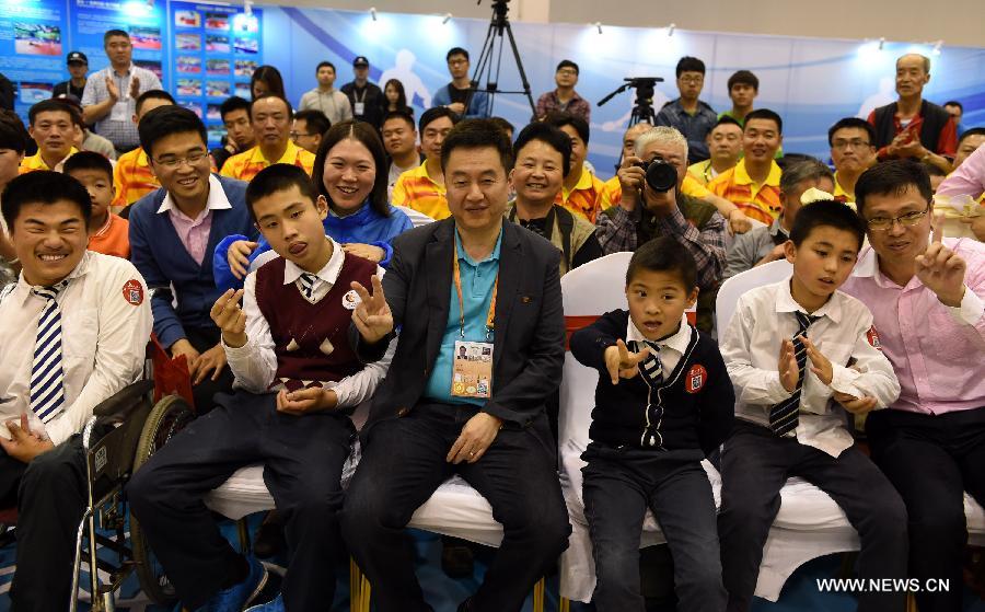 Shi Zhihao, Vice President of ITTF, takes photo with fans during a promotional movement in Suzhou, city of east China's Jiangsu Province and the host city of the 53rd Table Tennis World Championships. (Xinhua/Song Zhenping) 