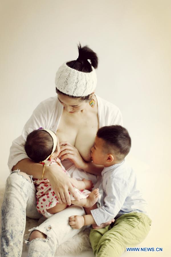 Photo provided by La Leche League-China shows a mother breastfeeding her children. May 20 is China's National Breastfeeding Awareness Day. As the pronounciation of '520' is close to 'I Love You,' many mothers feel meaningful to have their breastfeeding photos to make public. La Leche League-China, a branch of an international organization that provides mother-to-mother support, information and encouragment for breastfeeding, has collected art photos of breastfeeding mothers for three consecutive years. (Xinhua/La Leche League-China)  