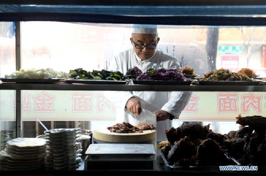 Ma Wenbin, an inheritor of Lanzhou beef lamian, prepares materials at a noodle shop in Lanzhou, capital of northwest China's Guansu Province, Jan. 22, 2014.