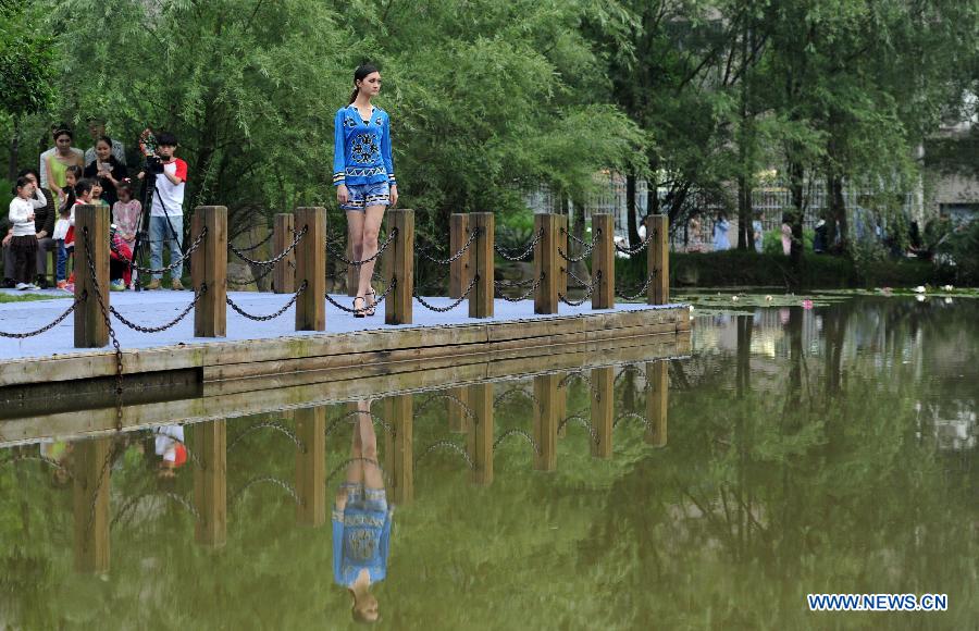 A model displays the creation of graduates in Hunan Arts and Crafts Vocational College in Yiyang, central China's Hunan Province, May 23, 2015.