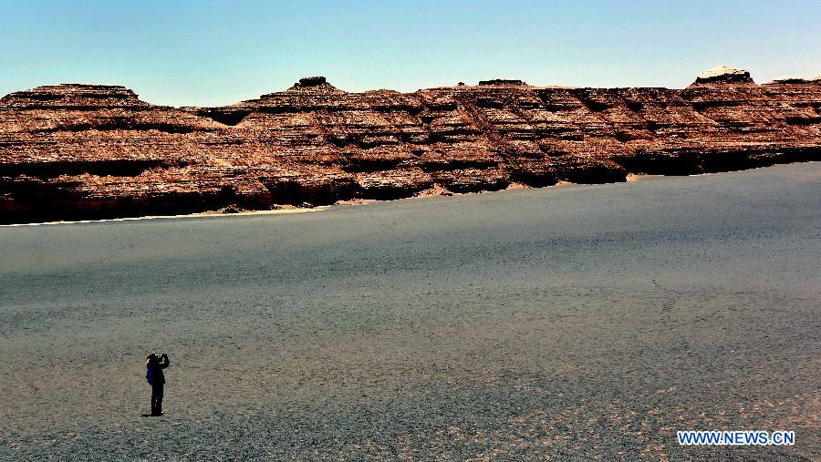 A tourist takes photo of yardang landforms at Dunhuang Yardang National Geopark in Dunhuang, northwest China's Gansu Province, May 24, 2015. (Xinhua/Wang Song)