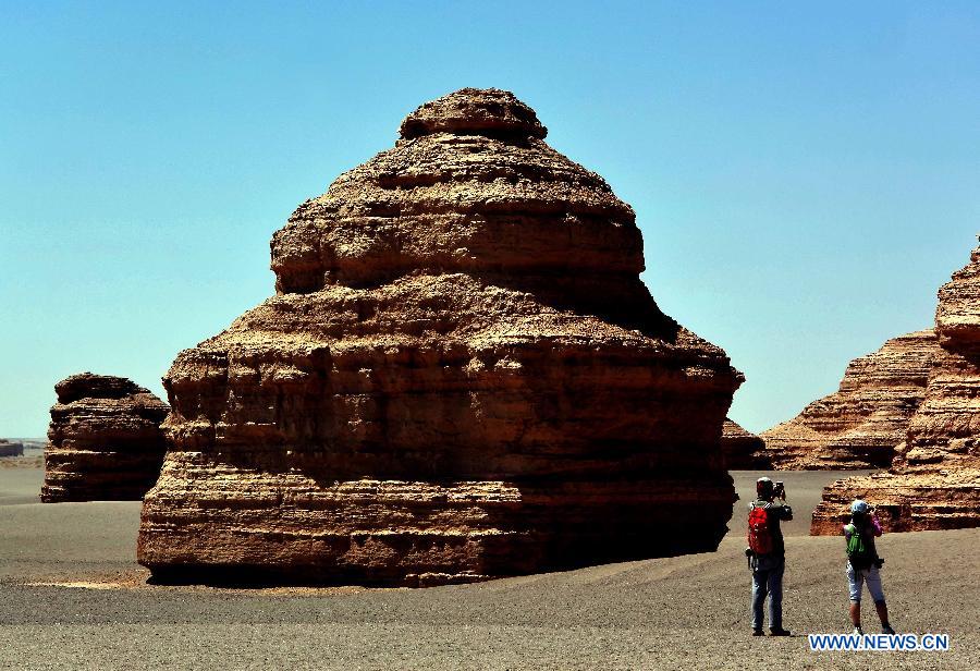 Tourists take photos of yardang landforms at Dunhuang Yardang National Geopark in Dunhuang, northwest China's Gansu Province, May 24, 2015. (Xinhua/Wang Song)