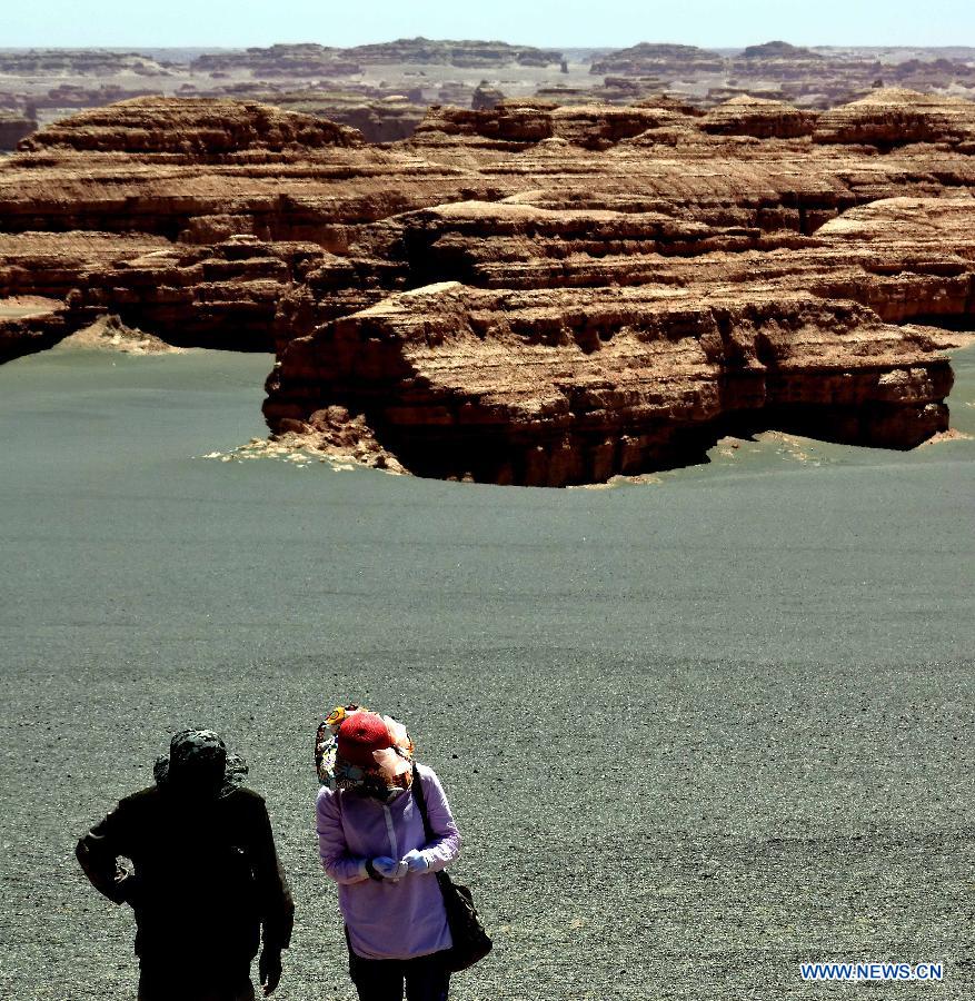 Tourists walk in the Dunhuang Yardang National Geopark in Dunhuang, northwest China's Gansu Province, May 24, 2015. (Xinhua/Wang Song)