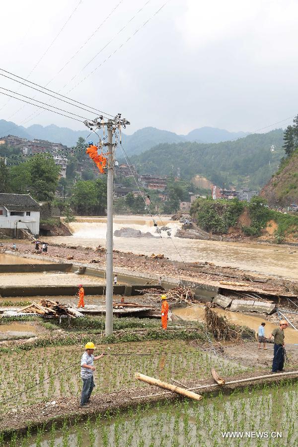 Workers of local power supply bureau repair electric equipments after rainstorms in Jiyong Village under Leishan County, southwest China's Guizhou Province, May 28, 2015.