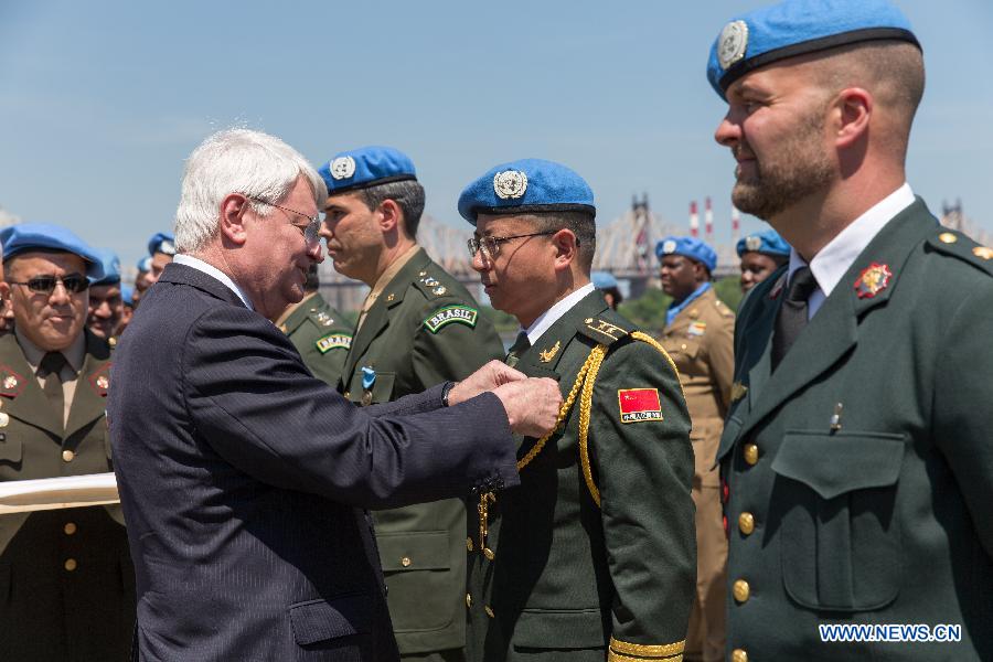 Military personnels salute during a wreath-laying ceremony held on International Day of UN Peacekeepers at the UN headquarters in New York, United States, May 29, 2015.