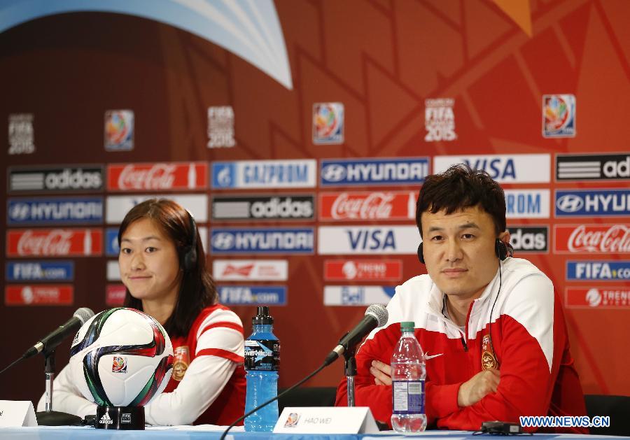 China's head coach Hao Wei (R) and captain Wu Haiyan attend a press conference at the Commonwealth Stadium in Edmonton, Canada, June 5, 2015. 