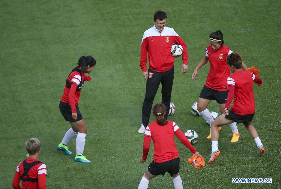 China's head coach Hao Wei (Back) instructs players during a training session at the Commonwealth Stadium in Edmonton, Canada, June 5, 2015.