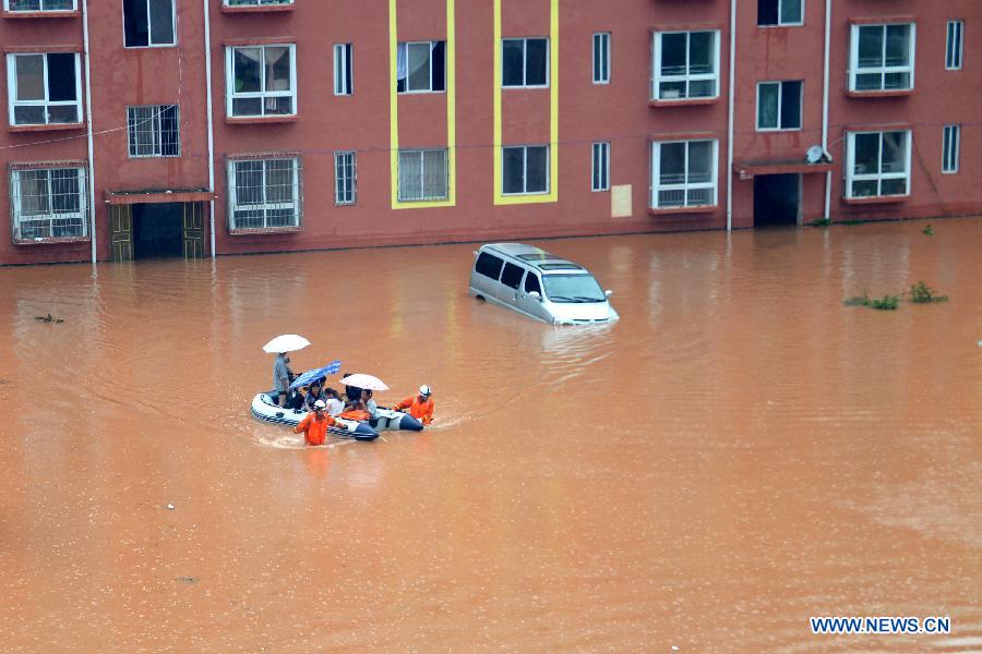 Rescuers transfer people trapped by flood to safe place in Yuqing County, Zunyi City of southwest China's Guizhou Province, June 10, 2015. 