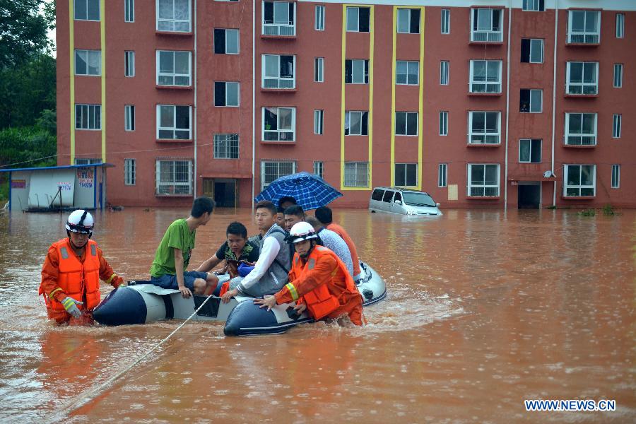 Rescuers transfer people trapped by flood to safe place in Yuqing County, Zunyi City of southwest China's Guizhou Province, June 10, 2015. 