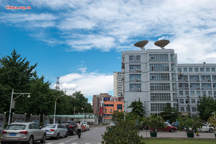 The sky above Capital Normal University in downtown Beijing is a crystal-clear blue on Thursday, June 11, 2015, after days of thunderstorms. Sunshine piercing through the white clouds brings a summery look to everything in the city below. [Photo by Chen Boyuan / China.org.cn]