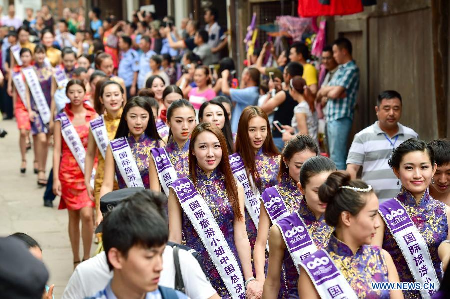 Contestants of the 2015 Miss Tourism Queen International of China division walk in Anju ancient town of southwest China's Chongqing Municipality, June 12, 2015.