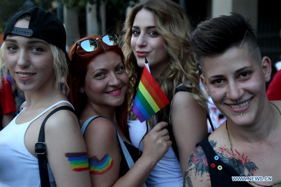Protesters pose with rainbow flags during an annual Gay Pride rally in Athens, Greece, June 13, 2015.